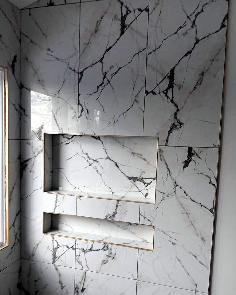 Walk-in shower in white marble-look tile with two long recessed niches